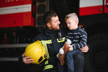 Wall Mural - Firefighter holding child boy to save him in fire and smoke,Firemen rescue the boys from fire