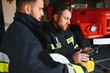 © Serhii - Portrait of two firefighters in fire fighting operation, fireman in protective clothing and helmet using tablet computer in action fighting