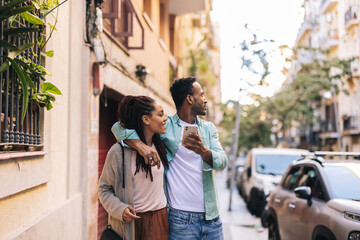 Wall Mural - couple tourists in the city - african american travelers with smart phone