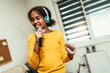 Cute preteen black girl  holding microphon singing karaoke at home, recording songs for contest. Children's lifestyle concept
