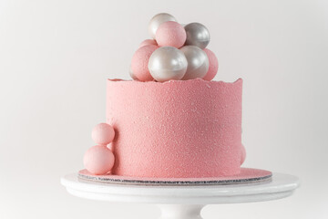 Canvas Print - Birthday cake with pink velvet sprayed coating decorated with silver and pink chocolate spheres on the white background