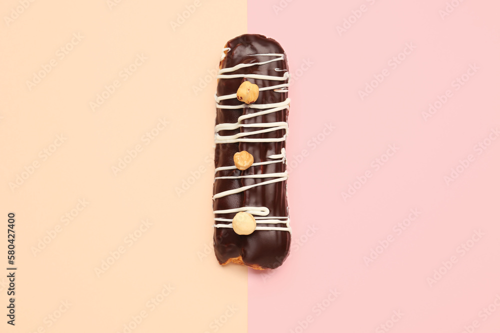 Tasty chocolate eclair on yellow and pink background
