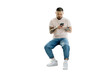 Serious handsome Korean man holding mobile phone shopping online isolated on transparent background. Young hipster guy with stylish tattoos on his hands chatting, reading text message. Clipping path  