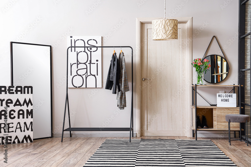 Interior of modern hall with rack, mirrors and door