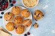 Fruity whole grain muffins with raspberries and blueberries on a blue background. Top view, copy space