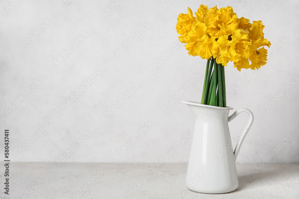 Vase with narcissus flowers on white table