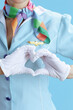 © Alliance - Modern female stewardess on blue showing heart hands