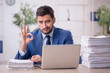 © Elnur - Young male employee and too much work in the office