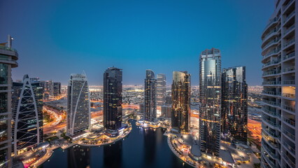  Tall residential buildings at JLT aerial day to night timelapse, part of the Dubai multi commodities centre mixed-use district.