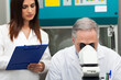 © Minerva Studio - Senior scientist using a microscope in his laboratory