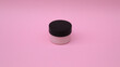Envase pequeño de color rosa sin marca, para producto cosmético. 