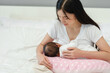 © geargodz - mother breastfeeding newborn baby on support pillow cushion