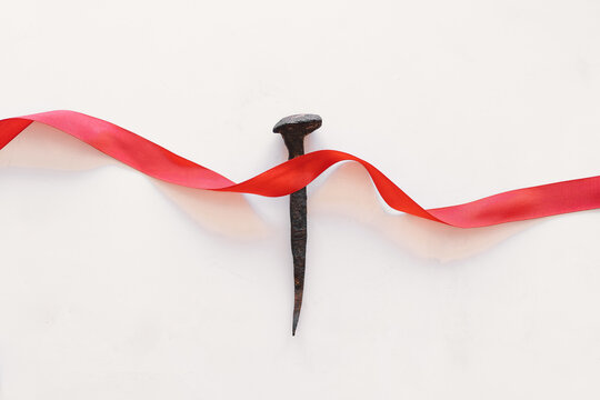 a nail with a red ribbon, a symbol of christ. crucifixion of jesus christ. passion of jesus christ. 