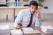 © Elnur - Young male employee and too much work in the office