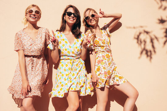 three young beautiful smiling hipster female in trendy summer dresses clothes. sexy carefree women p