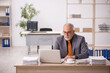 © Elnur - Old male employee working at workplace