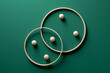 Crossing wooden rings with spheres on green background.