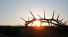 The Cross And Crown Of Thorns Symbolizing The Sacrifice And Suffering Of Jesus Christ And The Red Sunset, Passion Week And Lent Concept
