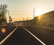© Cavan Images - Rear view of man walking on railroad track during sunset