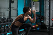 © Cavan Images - Determined woman listening music while exercising in gym
