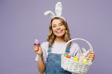Young Smiling Positive Fun Cheerful Woman Wearing Casual Clothes Bunny Rabbit Ears Hold Wicker Basket Show Colorful Egg Isolated On Plain Pastel Purple Background Studio Portrait Happy Easter Concept