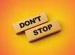 Wooden blocks with words do not stop on orange background 3d illustration