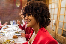 Happy Woman With Afro Hairstyle Having Dinner At Restaurant
