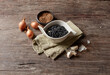 © Westend61 - Studio shot of bowl of black beans, raw onions and garlic