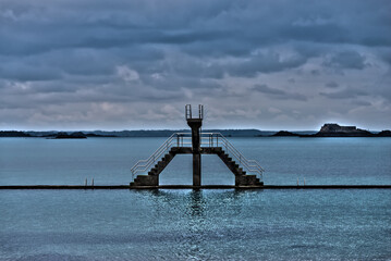 Diving board of the beach of Bon-Secours in Saint-Malo. Dominant color blue. Quiet scene.