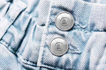 Wall Mural - Blue jeans denim fabric. Grunge fashion background pattern with closeup on metal button. Zipper double button.
