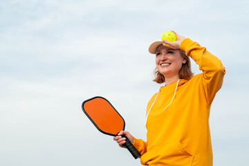 portrait woman player pickleball game over blue sky, pickleball yellow ball with paddle, outdoor sport leisure activity, copyspace for text