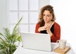 © Retamosa - a woman working on a laptop computer at home