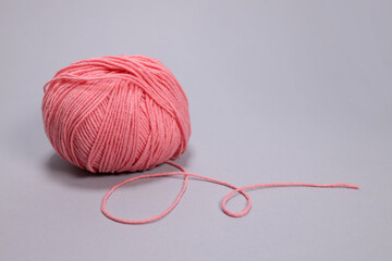 Wall Mural - Pink ball of wool on a gray background