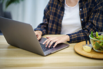 Happy beautiful Asian woman using computer laptop for work online at living room