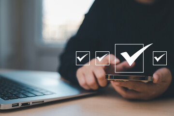 Businessman hold Smartphone with Taking assessment, questionnaire, evaluation, online survey online exam Choosing the right answer in exam by filling out the online survey form,Answer  test questions