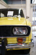 A close up look at yellow classic car. Retro automobile exterior scene. Front detail view of old vehicle.