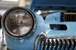 A close up look at blue classic car. Retro automobile exterior scene. Front detail view of old vehicle.