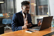 © JustLife - Portrait of successful businessman in office. Young smiling man using the laptop.