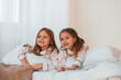 © standret - Lying down on the bed. Two little girls are playing and having fun together in domestic room