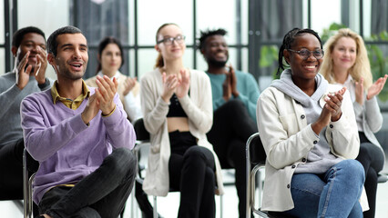 Wall Mural - Selective focus of young businesswoman applauding together with interracial colleagues during seminar