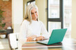 © kues1 - senior pretty woman smiling and looking with a happy confident expression with a laptop
