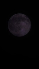 Wall Mural - Magical full moon at night. Telephoto view of mysterious clouds flying against the bright full moon. Real midnight footage with black background and copy space. Creepy halloween sky, astrology concept