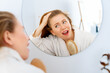 woman looking at scalp in mirror