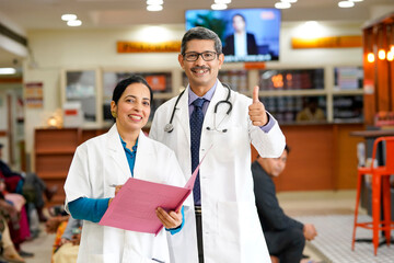 Wall Mural - Indian male doctor showing thumps up at hospital.