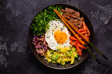 traditional korean dish bibimbap: rice with vegetables beef and egg.