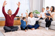 © Tongpool - The family have fun relax engaged in fitness yoga at home using online instruction from laptop