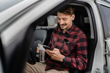 Man Hold Cup With Coffee Use Mobile Phone Sit In The Car Take A Brake