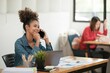 © Treerat - Smart African women working in beautiful office, working on Laptop, use the phone, talking on the cellphone.