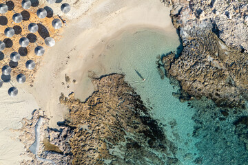 Drone aerial of beach umbrellas in the beach. Summer holidays in the sea.