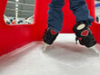 Beginner ice skater using a plastic walker for assistance.